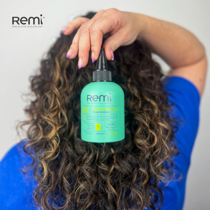 Person holding a green bottle labeled 'Remi' against a plain background