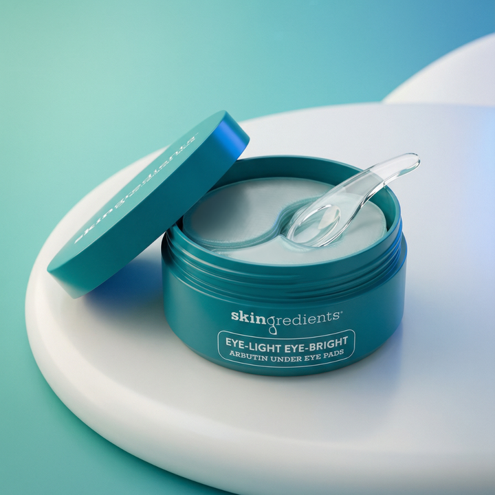 Blue jar of 'skin ingredients' eye pads with a spoon on a light blue background