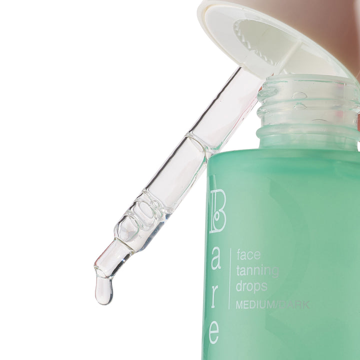 Bare face tanning drops with dropper on a white background