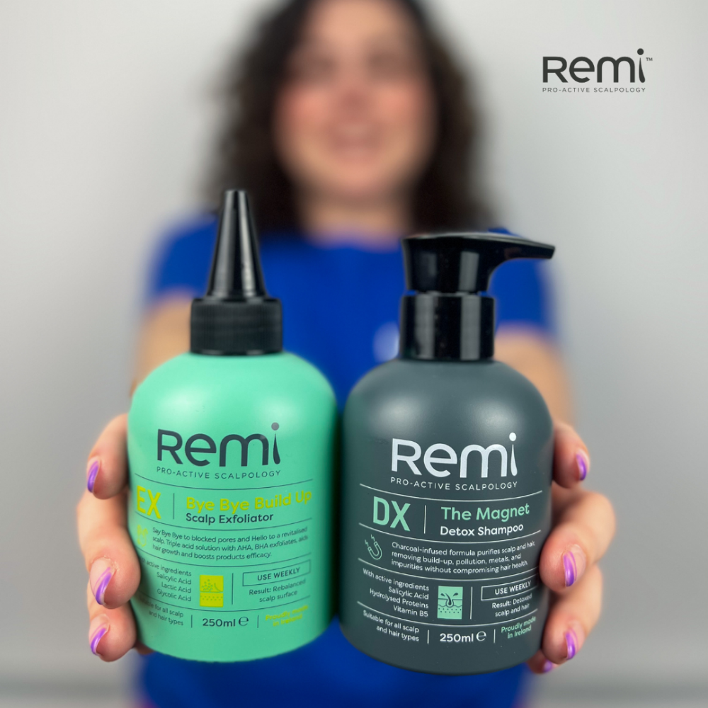 Two bottles of Remi hair care products held by a person with a blurred background