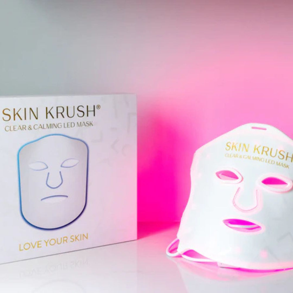 Clear and Calming LED Mask, white silicone facial mask with pink LED openings beside branded packaging