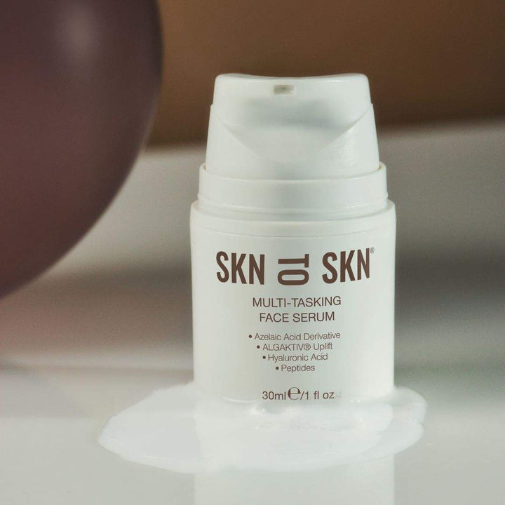 Multi-Tasking Face Serum in a white airless pump bottle with brown SKN to SKN branding and ingredient text
