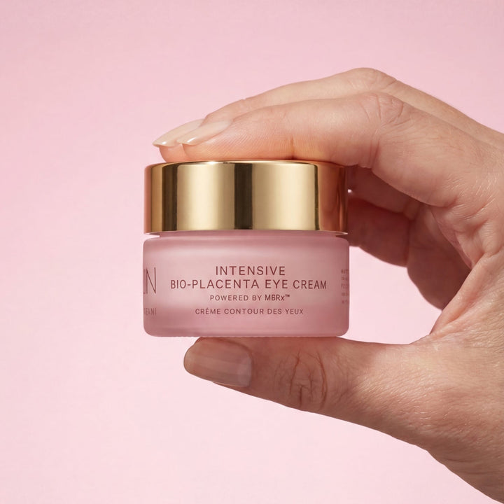 MZ Skin Intensive Bio-Placenta Eye Cream in a pink glass jar with a reflective gold lid