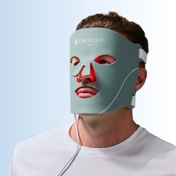 Omnilux Men LED Mask in sage green silicone with red LED light visible around the eyes and nose
