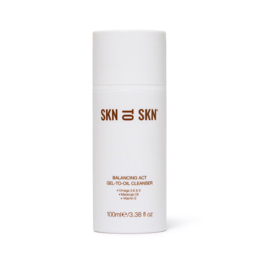 Skn to Skn Balancing Act Gel-To-Oil Cleanser in a white cylindrical pump bottle with brown branding