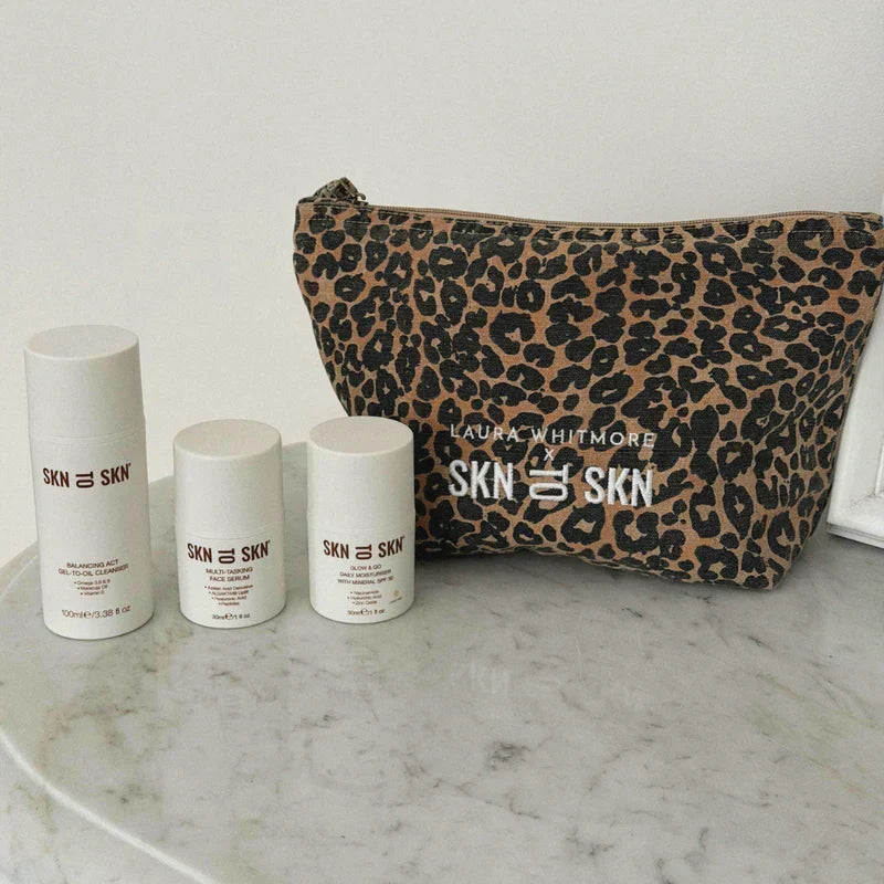 Skn to Skn Laura Whitmore skincare gift set with white bottles and leopard print cosmetic bag featuring brand logo
