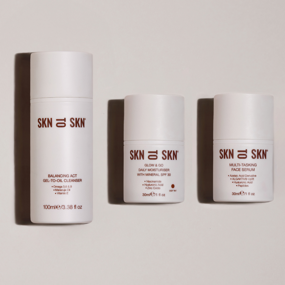 Skn to Skn Laura Whitmore skincare set with white minimalist bottles including Balancing Act Gel-To-Oil Cleanser, Glow & Go Daily Moisturiser with SPF 30, and Multi-Tasking Face Serum