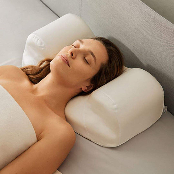 Sleep and Glow anti-aging pillow in white ergonomic foam, supporting a woman’s head and neck while sleeping on her back